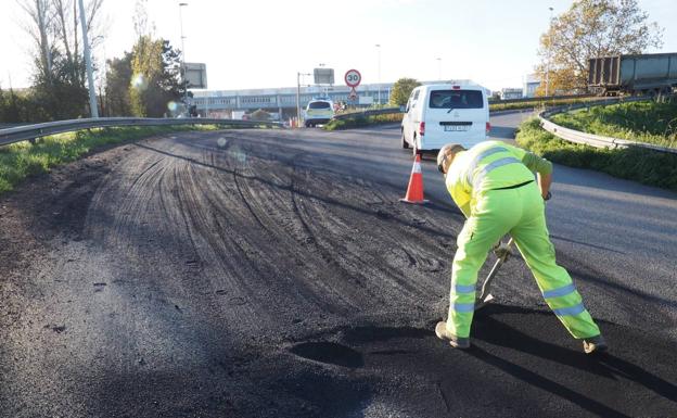 Un operario limpia el carbón derramado en el acceso a la Ciudad del Transporte de Santander.