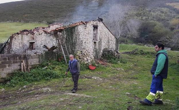 Arturo Nebreda, en primer término, y su suegro, Jacinto Salas, junto a los restos de la cabaña. 