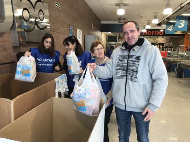 Voluntarios recogen las donaciones de alimentos en un supermercado Lupa de la capital.