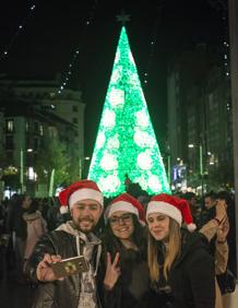 Imagen secundaria 2 - Arriba, árbol alumbrado en Piélagos. Debajo, caracoles a la venta en el Mercado de la Esperanza de Santander y el árbol de Navidad de la Plaza del Ayuntamiento de Santander.