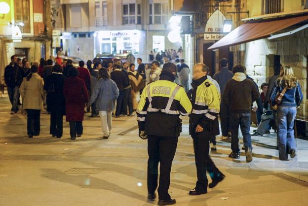 Agentes de la Policía Local de Torrelavega patrullan por las calles de la conocida como zona de vinos de la ciudad. 