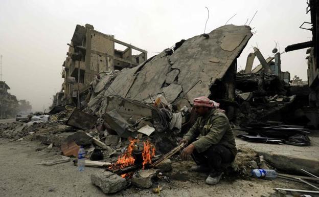 Un sirio, junto a una hoguera en la ciudad de Raqa.