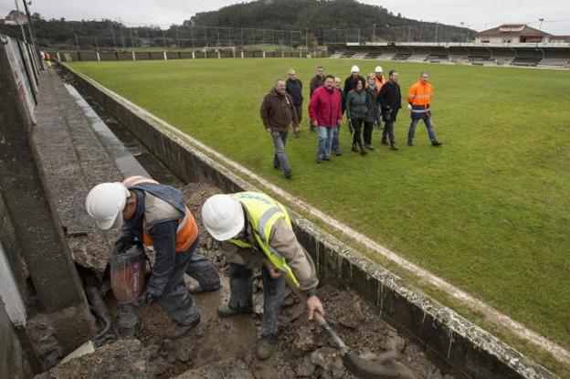 Operarios trabajan en la mejora del campo de fútbol de Escobedo. 