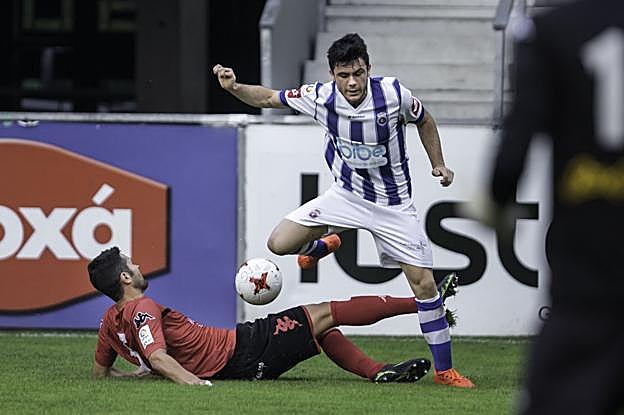 Fermín, de la Gimnástica, trata de controlar el balón frente a Álvaro Cano, del Laredo. 