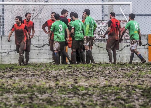 Los jugadores del Sámano y del Laredo, el pasado sábado sobre el 'patatal' en que se ha convertido el campo de Vallegón.