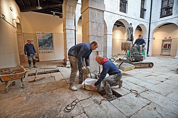 Los operarios trabajan sobre las losas del corredor que rodea al patio central del Espolón
