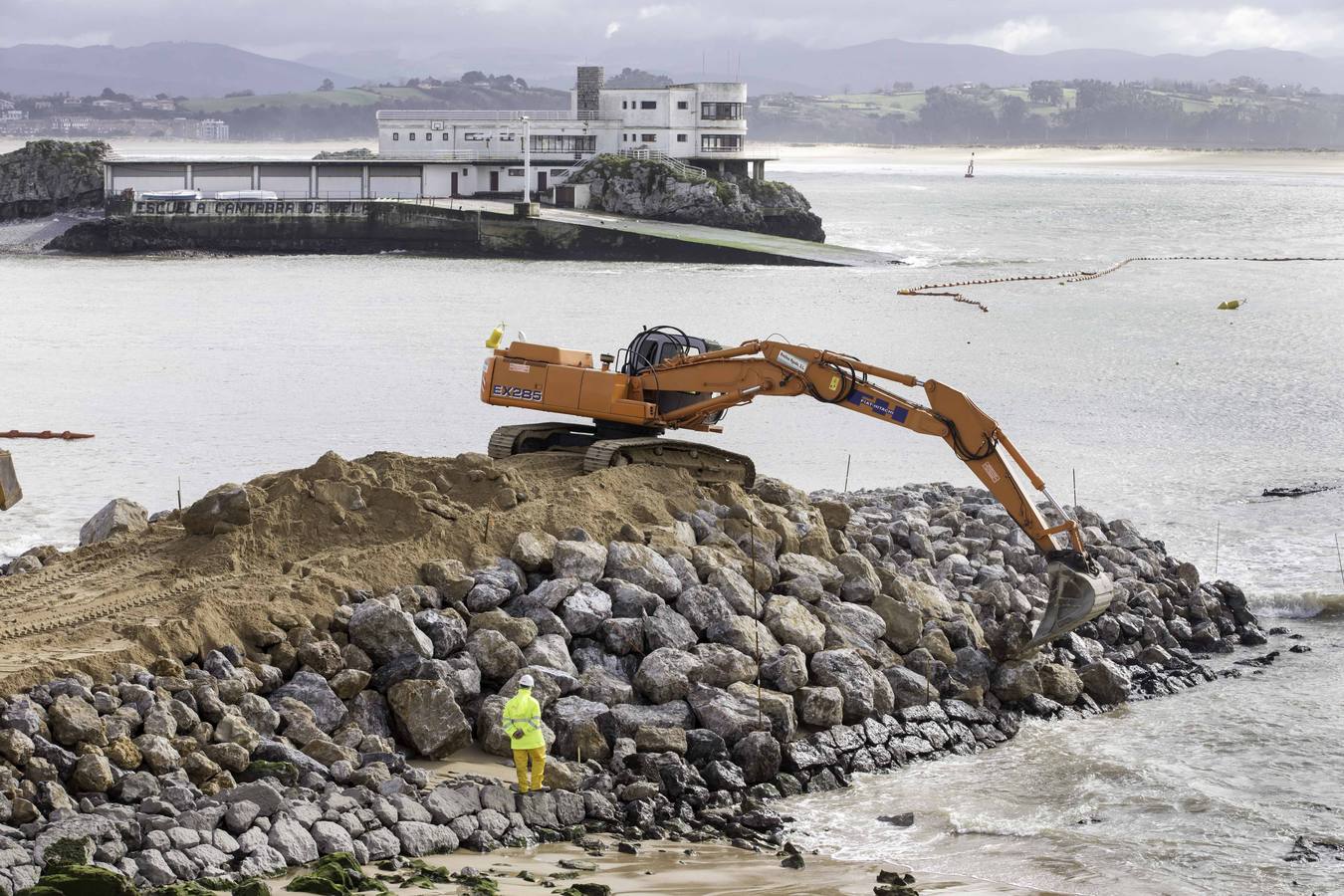 El primer dique para contener la arena ya asoma de forma evidente en La Magdalena.Con la playa cortada y la marea baja, la pala da forma al primero de los espigones, que llama la atención de los curiosos que se acercan a verlo 