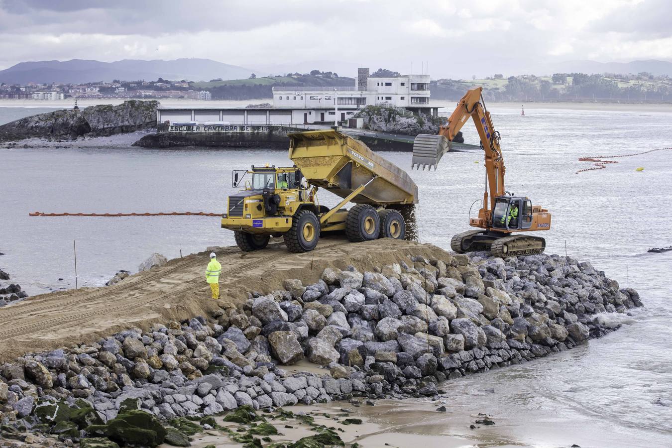 El primer dique para contener la arena ya asoma de forma evidente en La Magdalena.Con la playa cortada y la marea baja, la pala da forma al primero de los espigones, que llama la atención de los curiosos que se acercan a verlo 