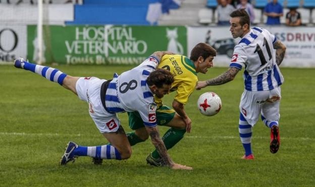 Palazuelos y Perry, de la Gimnástica, luchan por el balón con Pablo, del Tropezón. 