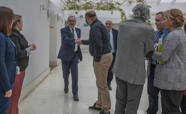 El rector Ángel Pazos saluda al diputado socialista Víctor Casal, ayer, antes de su comparecencia parlamentaria 