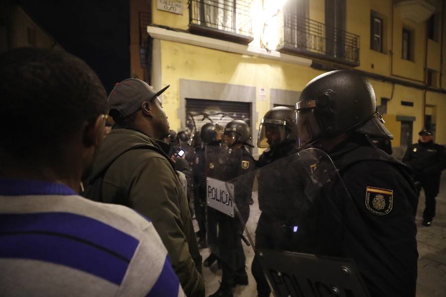 Un grupo de más de medio centenar de personas han quemado contenedores y causado desperfectos en el mobiliario urbano en el madrileño barrio de Lavapiés tras la muerte este jueves de un mantero de 35 años y origen subsahariano a causa de una parada cardiorrespiratoria.