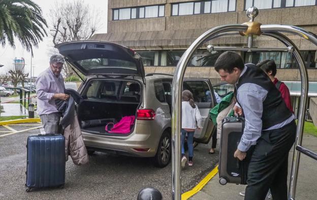 Una familia de turistas baja del coche las maletas a su llegada al hotel Santemar de la capital.