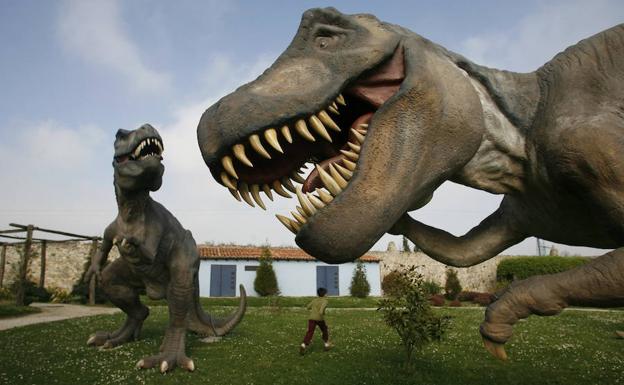 Niño contempla algunos de los 16 gigantes prehistóricos a tamaño real que se explonen en el Parque Dinosaurio, en Santillana del Mar. 