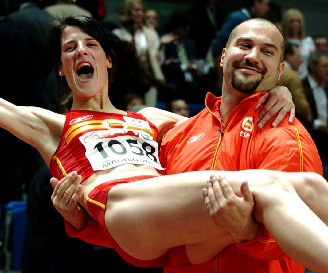 Manuel Martínez, bronce en lanzamiento de peso, sostiene a Ruth Beitia tras ganar la plata en salto de altura durante los Campeonatos de Europa de Atletismo en pista cubierta que se celebraron en 2005 en Madrid.