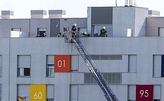 Los bomberos actuando en lo alto del edificio en el que se produjo el incendio.