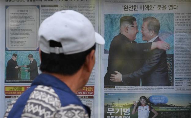Un hombre observa el abrazo entre Kim Jong-un y Moon Jae-in.