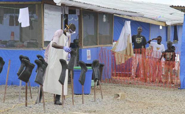 Un funcionario de salud de Kenia guia a un joven pasajero que llega al área de observación en el Aeropuerto Internacional Jomo Kenyatta en Nairobi. 