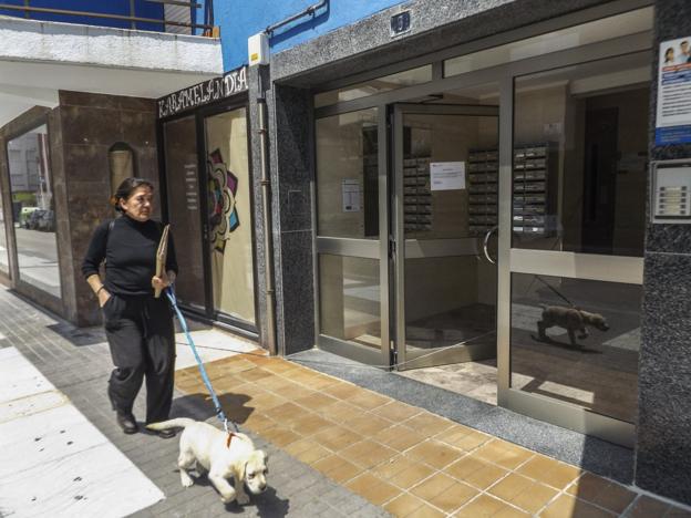 Mercedes Vicente pasea con su perro frente al portal de la vivienda en que reside y que mañana tendrá que abandonar. 