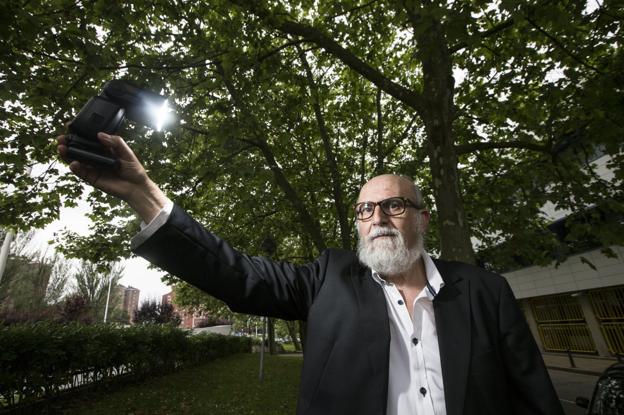 José Sánchez sostiene la luz que utiliza el fotógrafo para completar su retrato. :