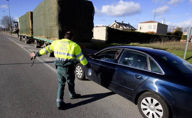 Un agente de la Guardia Civil para a un vehículo en un control de alcoholemia.