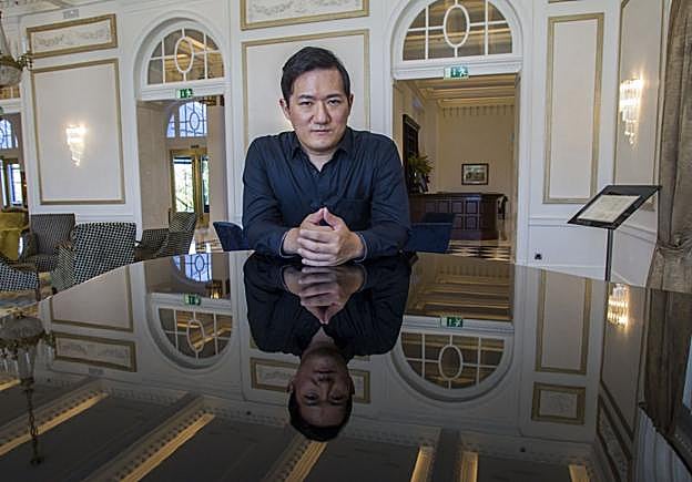 Ian Yungwook Yoo posa apoyado sobre un piano de cola en los salones del Hotel Real de Santander.