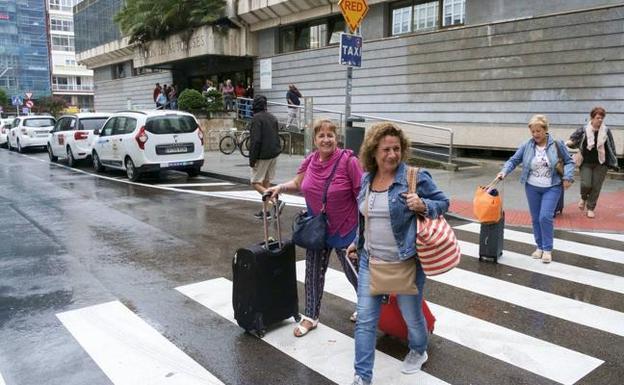 Un grupo de turistas fue andando, ayer, desde la estación de autobuses hasta su hotel con motivo de la huelga de taxis