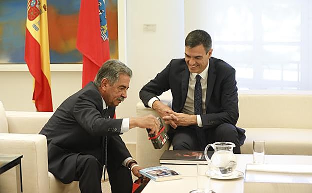 Momento en el que Revilla regala dos libros -uno suyo- y anchoas a Pedro Sánchez, ayer en la Moncloa.