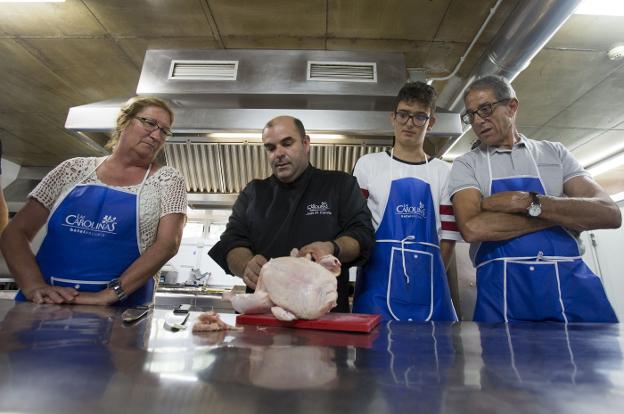 El chef y profesor Juanma España, segundo por izquierda, enseña técnicas de cocina a sus alumnos.