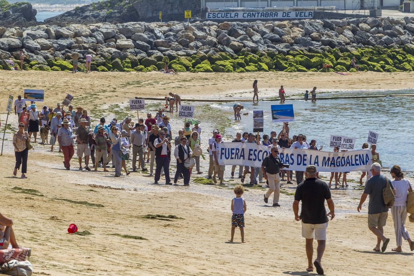 La plataforma ciudadana 'Salvar La Magdalena' ha celebrado hoy una nueva concentración para pedir la retirada de las escolleras que se están ejecutando en el arenal. El acto se ha celebrado en el Balneario de la Magdalena a las 12.30 horas y, además de la concentración en sí, ha incluido un 'pasaplayas'. Los manifestantes han aprovechado la bajamar para realizar un paseo por la orilla encabezado por un pito y tamboril con globos, pancartas y camisetas reivindicativas.