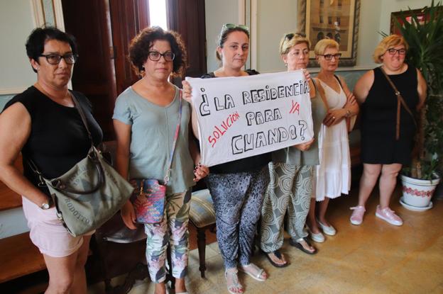 Seis trabajadoras de la Residencia municipal mostraron una pancarta en el pleno pidiendo solución a la falta de personal.