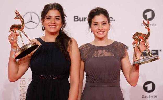 Las nadadoras Sarah (i) y Yusra (ii) Mardini sostienen sus trofeos de los premios Bambi. 