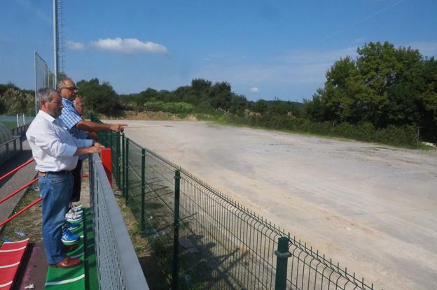 Directivos del equipo de fútbol de Tanos, el Tropezón, muestran la zona en la que se hará la obra.