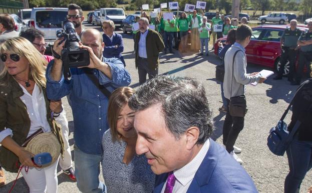 Mañanes, este martes, en la inauguración oficial del curso, y al fondo los representantes de los profesores pidiendo su dimisión. 