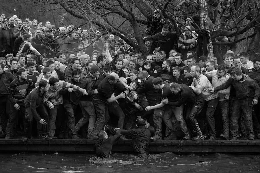 Los miembros de los equipos oponentes, los Up'ards y Down'ards, luchan por el balón durante el histórico y anual Torneo de Royal Shrovetide Football en Ashbourne, Derbyshire, Reino Unido.