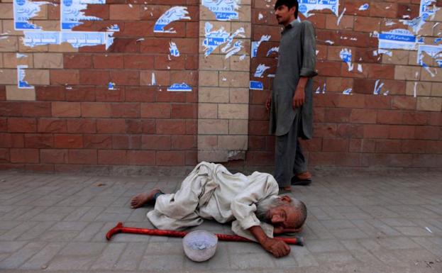 Un anciano sin hogar duerme en la calle en Peshawar (Pakistán). 