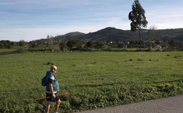 Un hombre camina junto a la zona en la que se pretende construir el parque empresarial de Las Excavadas. 