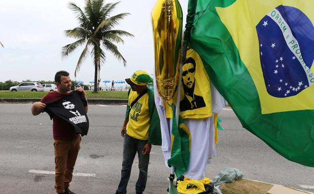 Un hombre negocia con el vendedor la compra de una camiseta de Jair Bolsonaro.