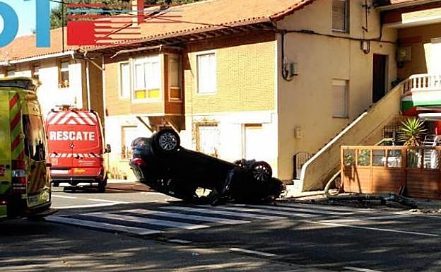 El coche volcado ocupa uno de los carriles de la carretera.