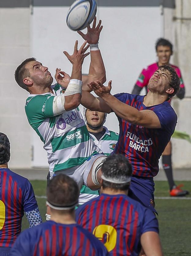 Yoel Soria salta a por el balón entre varios jugadores culés.