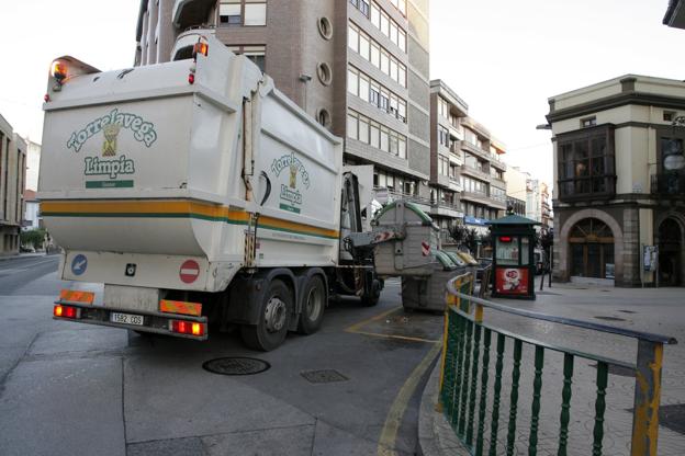 Un camión recoge un contenedor de basura en una calle del centro de la ciudad.