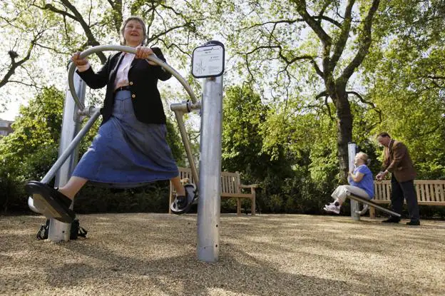 Varias personas mayores hacen ejercicios en un parque habilitado en Londres. 