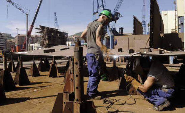 Dos empleados trabajando en un astillero.