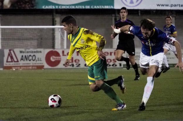 Cristopher controla el balón ante la oposición de un jugador del Barakaldo. 