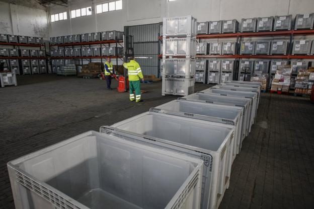 Aspecto de la nave de Tanos donde dos voluntarios preparan los contenedores en los que se organizarán los productos que se recauden durante el fin de semana.