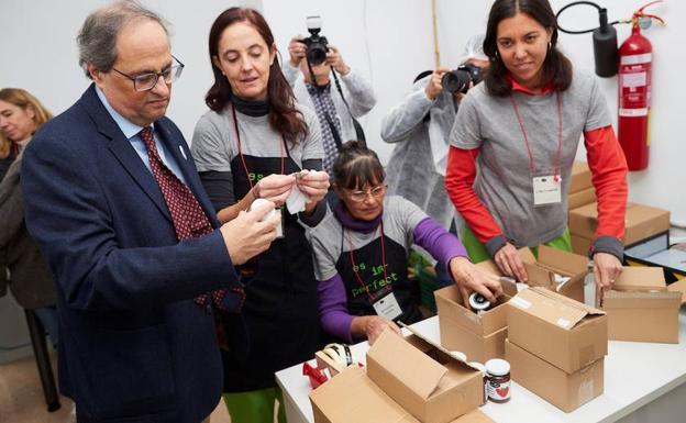 El presidente de la Generalitat, Quim Torra, conversa con varias trabajadoras durante la visitaa una compañía de reciclaje. 