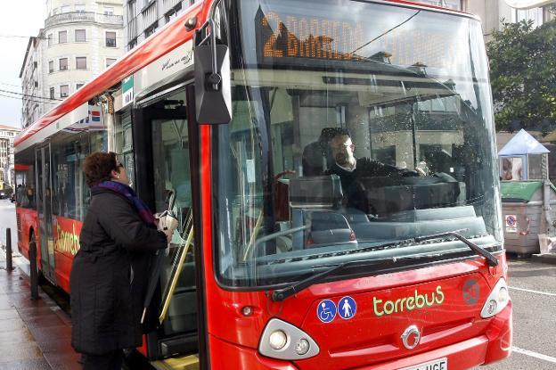 Una vecina habla con el conductor de uno de los autobuses en la calle José María Pereda. 