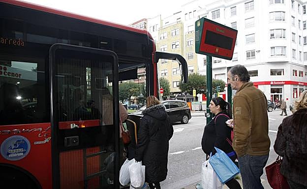 Varios usuarios esperan para subir al autobús urbano en Torrelavega.