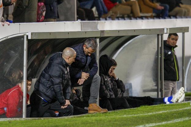 Pablo Lago consulta el reloj en el banquillo junto a Carlos Setién, segundo entrenador.