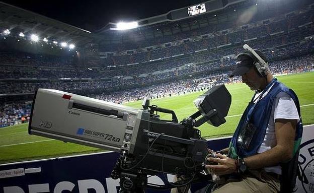 Un cámara de televisión retransmitiendo un partido de fútbol. 
