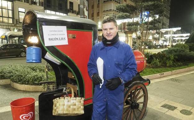 Julián Andrés Gutiérrez, junto a la locomotora de castañas de la calle Jesús de Monasterio, en Santander. 